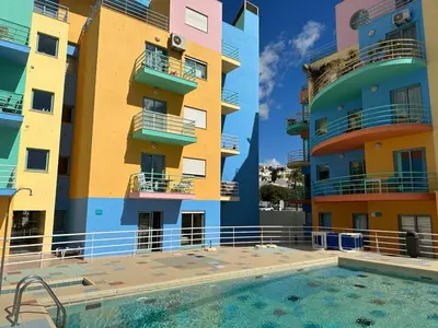 a building with a swimming pool in front of a building at Marina de Albufeira T2 até 6 pax Com Piscina e Vista Marina in Albufeira