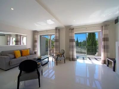a living room with a couch and a large window at Apartment Pine Hills Turquesa by Interhome in Vilamoura