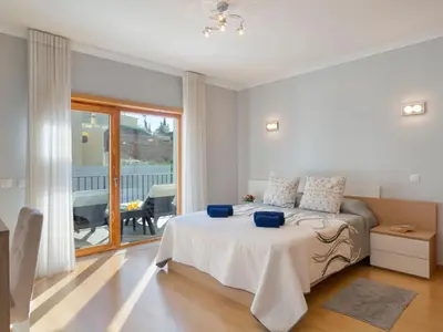 a white bedroom with a bed and a balcony at Villa Mathilda by Interhome in Albufeira