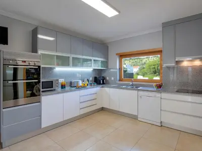 a large kitchen with white cabinets and a window at Villa Mathilda by Interhome in Albufeira