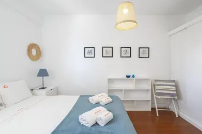 a white kitchen with a white table and chairs at Bright 2BR Apartment with Private Balcony - Albufeira Beach, by Hopstays in Albufeira