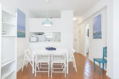 a living room with a blue couch and a table at Bright 2BR Apartment with Private Balcony - Albufeira Beach, by Hopstays in Albufeira