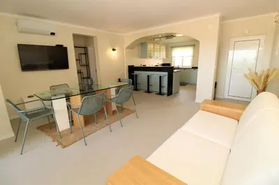 a living room with a glass table and chairs at Ocean View Hydrangea - 2 Bedroom Apartment at São Rafael Beach, Albufeira in Albufeira