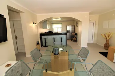 a living room with a glass table and chairs at Ocean View Hydrangea - 2 Bedroom Apartment at São Rafael Beach, Albufeira in Albufeira