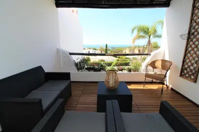a living room with a couch and a view of the ocean at Ocean View Hydrangea - 2 Bedroom Apartment at São Rafael Beach, Albufeira in Albufeira