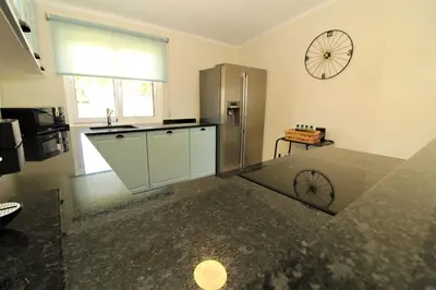 a kitchen with a refrigerator and a clock on the wall at Ocean View Hydrangea - 2 Bedroom Apartment at São Rafael Beach, Albufeira in Albufeira