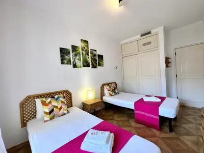 a room with two beds and a table at Vilamoura Palm Tree With Pool by Homing in Vilamoura