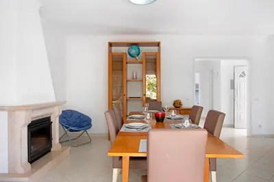 a dining room with a table and a fireplace at Villa Galé in Guia