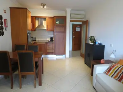 a kitchen and living room with a table and a couch at Apartamento - CERRO MAR in Albufeira