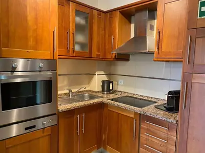 a kitchen with wooden cabinets and a stainless steel sink at Apartamento - CERRO MAR in Albufeira