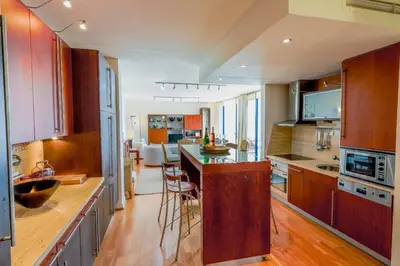 a kitchen with wooden cabinets and a kitchen island with a table at Apartamento Valerie in Vilamoura