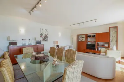 a living room with a glass table and chairs at Apartamento Valerie in Vilamoura