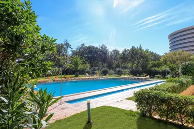 a large swimming pool in a park with trees at Apartamento Valerie in Vilamoura