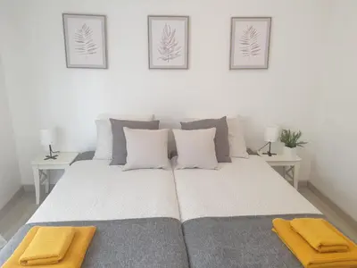 a bedroom with a large bed with two tables at Faro Casa da Baixa in Faro