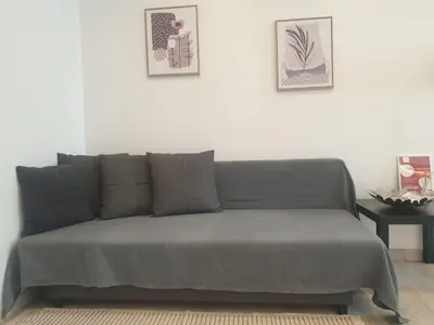 a couch in a living room with two pictures on the wall at Faro Casa da Baixa in Faro
