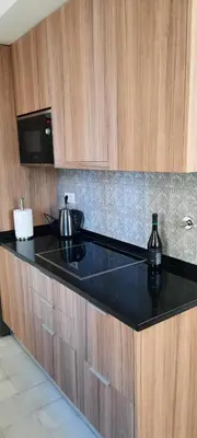 a kitchen with a black counter top with a tea kettle at Casa da Açoteia - Bright City Center Apartment with a Private Outdoor Terrace in Faro
