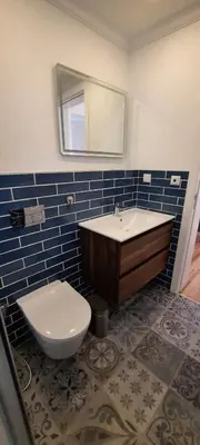 a bathroom with a sink and a toilet and a mirror at Casa da Açoteia - Bright City Center Apartment with a Private Outdoor Terrace in Faro