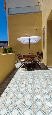 a table and chairs with an umbrella on a patio at Casa da Açoteia - Bright City Center Apartment with a Private Outdoor Terrace in Faro