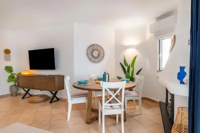 a living room with a table and a tv at Clube Albufeira: 2BR Prime Holidays Retreat in Albufeira