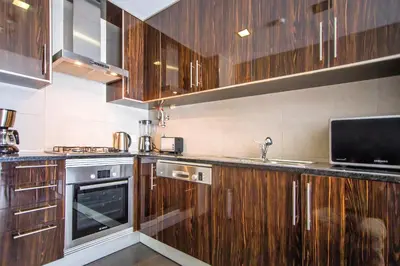 a kitchen with wooden cabinets and a sink at Blue Wave Apartment in Albufeira
