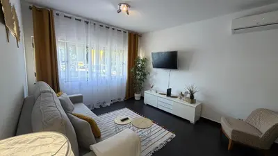 a living room with a couch and a tv at Blue Wave Apartment in Albufeira