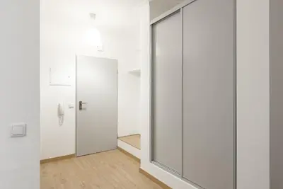 a pivot door in a white room with a mirror at Miral Beachside 1 - by HD Properties in Albufeira