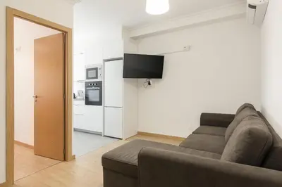 a living room with a couch and a kitchen at Miral Beachside 1 - by HD Properties in Albufeira