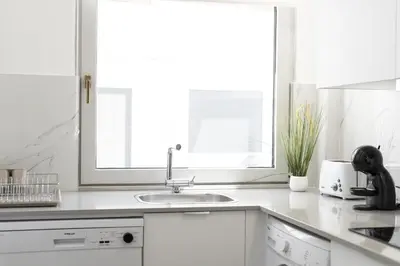 a white kitchen with a sink and a window at Miral Beachside 1 - by HD Properties in Albufeira