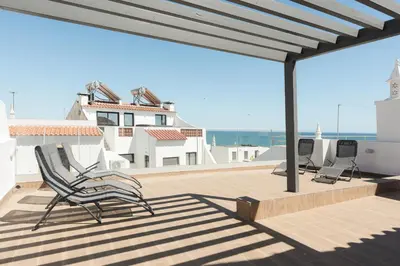 a deck with chairs and a view of the ocean at Miral Beachside 4 - by HD Properties in Albufeira