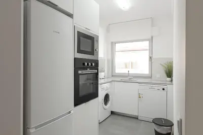 a white kitchen with a stove and a microwave at Miral Beachside 4 - by HD Properties in Albufeira