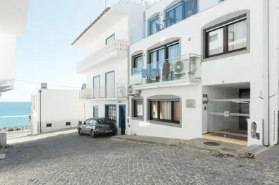 a white building with a car parked in front of it at Miral Beachside 5 - by HD Properties in Albufeira