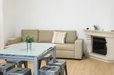 a living room with a couch and a table with stools at Miral Beachside 2 - by HD Properties in Albufeira