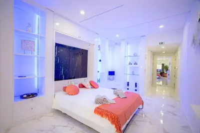 a white bedroom with a bed and a large window at Dubai Apartment in Albufeira