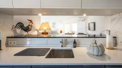 a kitchen with a sink and a rooster statue on the counter at MarGalé - Swimming Pool - Beach - BY BEDZY in Galé