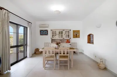 a white dining room with a table and chairs at Casa da Oliveira in Loulé