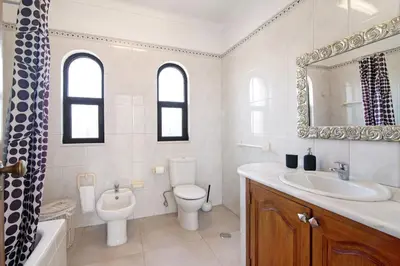 a bathroom with a sink and a toilet and a mirror at Casa da Oliveira in Loulé