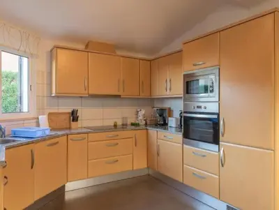 a large kitchen with wooden cabinets and appliances at Villa Savannah - Close to fisherman beach in Albufeira