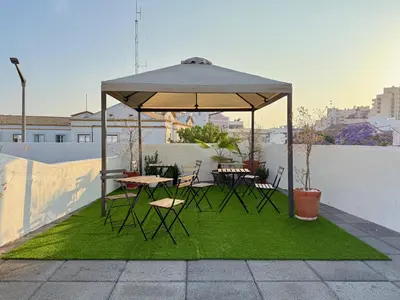 a gazebo with tables and chairs on top of grass at Casa Sebastião in Faro