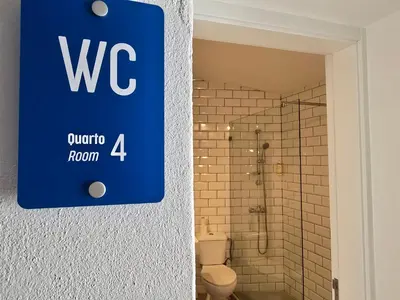 a bathroom with awwaho room sign on the wall at Casa Sebastião in Faro