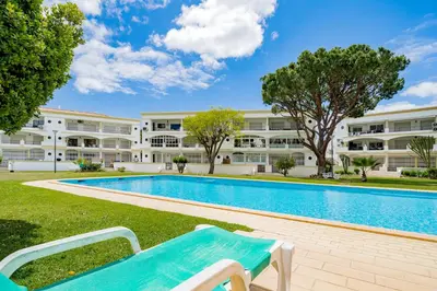 a swimming pool in front of a building at Melvin Jones St. 2bedroom apartment in Quarteira