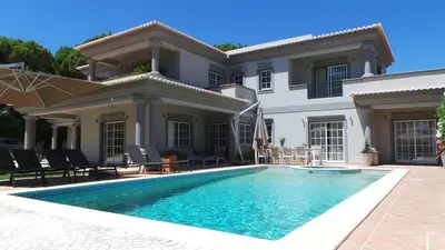 a swimming pool in front of a house at Villa Selena - Beautiful Luxury villa with massage baths in Quinta do Lago