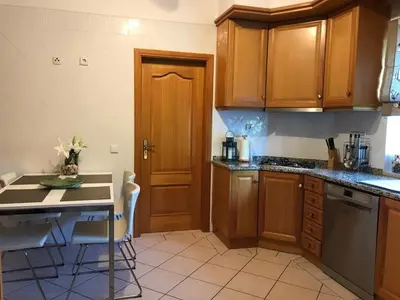 a kitchen with wooden cabinets and a counter top at Villa Selena - Beautiful Luxury villa with massage baths in Quinta do Lago