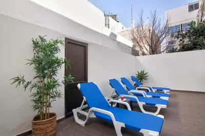 a row of blue chairs sitting on a balcony at Casa da Letinhas in Albufeira