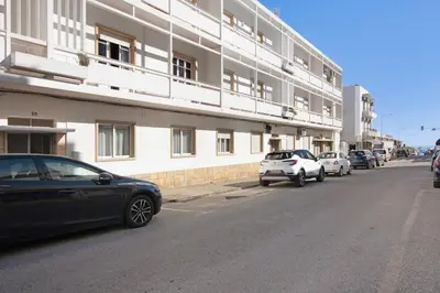 a street with cars parked in front of a building at Casa da Letinhas in Albufeira