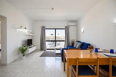 a white shelf with a clock and a vase on it at The Albufeira Concierge - Pool & Sunset Balconies in Albufeira