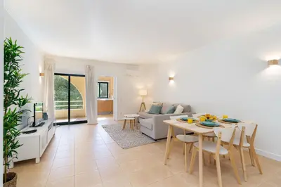 a living room with a table and a couch at Salgados Sunny Beach Apt - 7 min walk from Beach by Lisbeyond in Guia