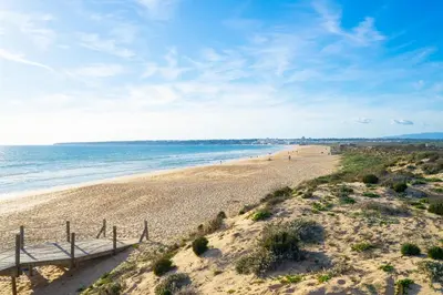 a view of a beach with a wooden boardwalk at Salgados Sunny Beach Apt - 7 min walk from Beach by Lisbeyond in Guia