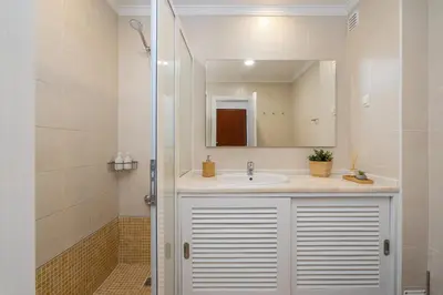 a bathroom with a sink and a mirror at Salgados Sunny Beach Apt - 7 min walk from Beach by Lisbeyond in Guia