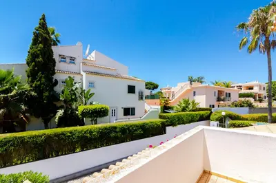 a view of a white house with trees and bushes at Small Villa 4Pax -Shared Pool @ Homesbyfc in Albufeira