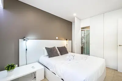 a bedroom with a white bed and a white desk at BeGuest Aveiros Beach View Apartment in Albufeira